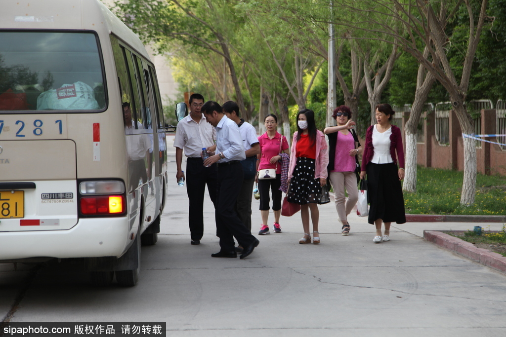 新疆哈密：高考第一日 低年級學(xué)生家長送考沿路壯行
