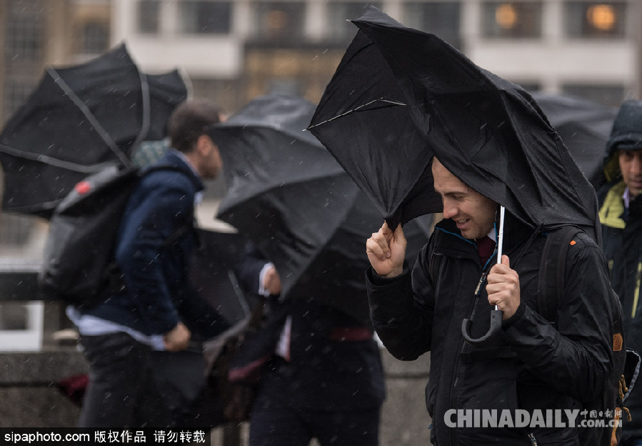 英國倫敦雨天狂風(fēng)大作 民眾出行雨傘被吹翻