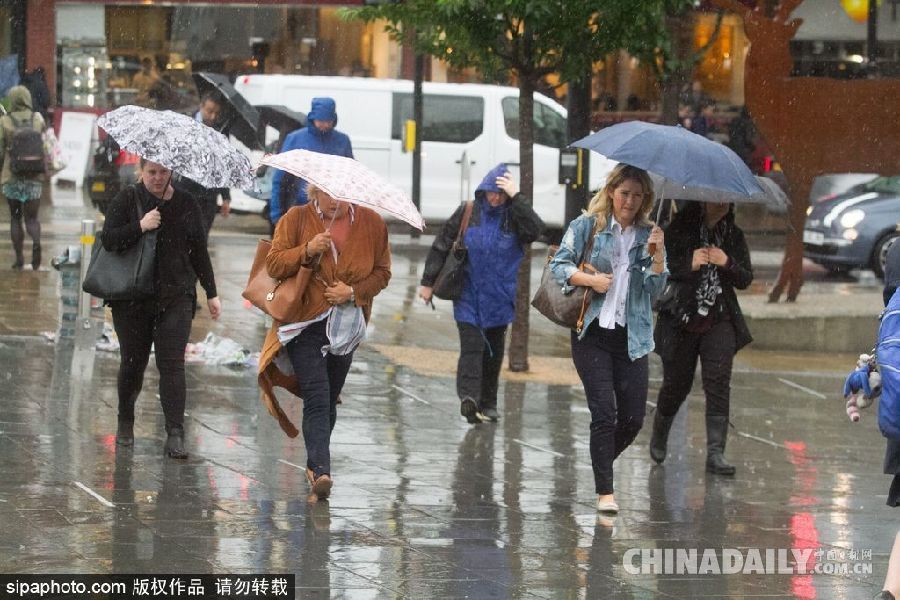 英國(guó)倫敦雨天狂風(fēng)大作 民眾出行雨傘被吹翻