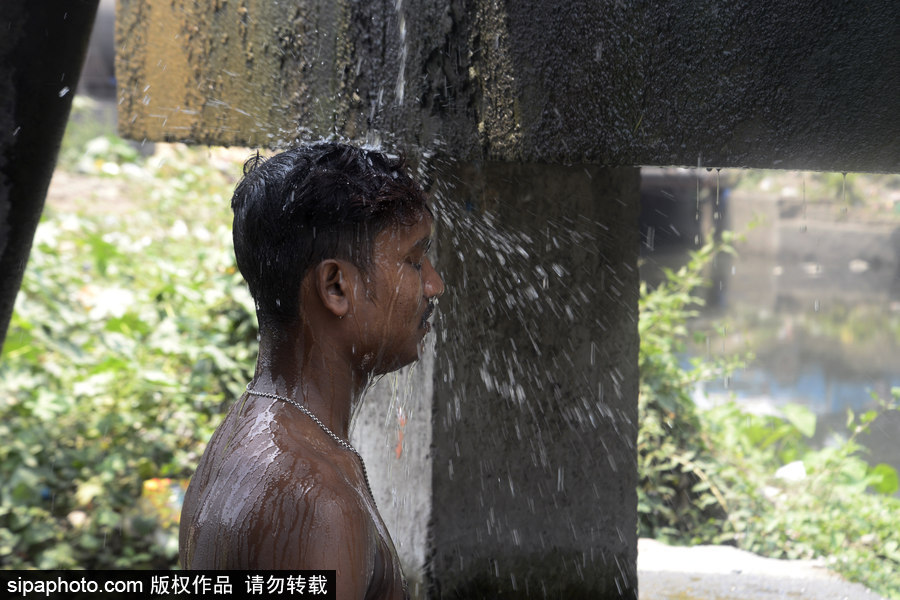 印度加爾各答高溫來(lái)襲 民眾室外沖涼降溫