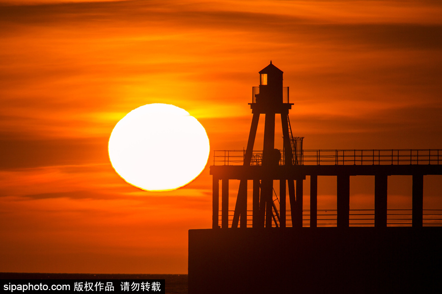 英國(guó)惠特比碼頭日出風(fēng)光 燈塔影影綽綽景色美